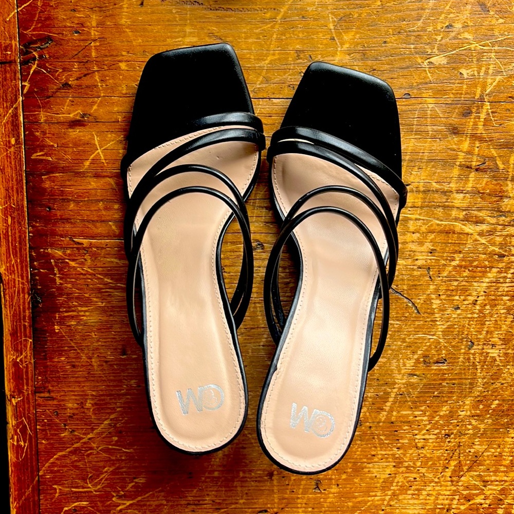 Black slip on sandals with strappy silhouette chunky heel.